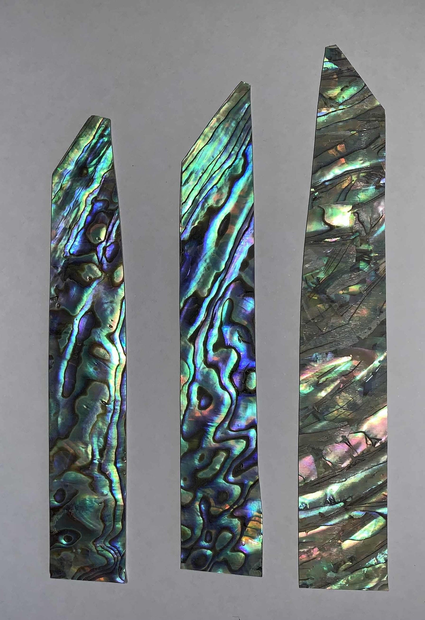 <p>Paua shell inlay feathers consist of single piece solid shell face layer 0.5mm thick laminated to shell laminate backing size 17-20mm width x 85-100mm length x .1.6mm total thickness (including 1.1mm laminated sheet backing). Suitable for inlays, marquetry.</p>