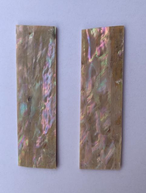 Awabi shell inlay feathers consist of single piece solid shell face layer 0.5mm thick laminated to shell laminate backing size 27mm width x 80-100mm length x .1.6mm total thickness (including 1.1mm laminated sheet backing). Suitable for inlays, marquetry. <br />
