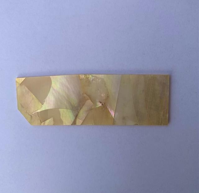 Gold MOP shell inlay feathers consist of single piece solid shell face layer 0.5mm thick laminated to shell laminate backing size 30 width x 70-90mm length x .1.6mm total thickness (including 1.1mm laminated sheet backing). Suitable for inlays, marquetry. <br />