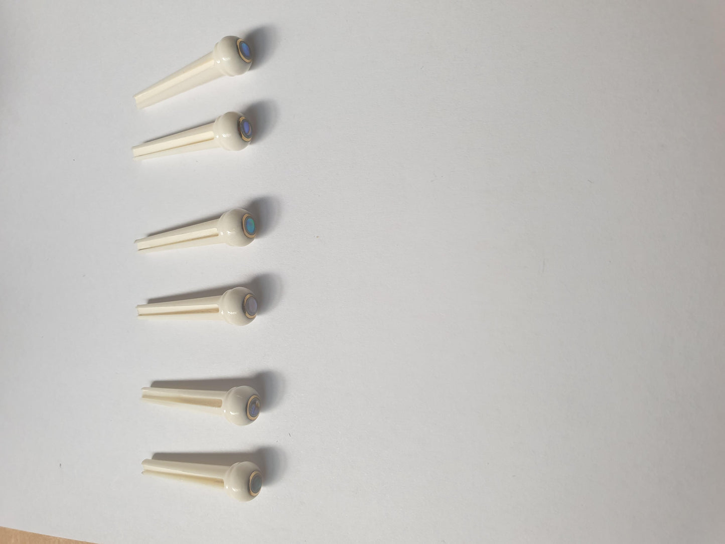 1 set (6pcs) Guitar bridge pins size 2A bone brass with Paua dot. Tapered shaft string slot running the full length of shaft. Diameter at top of shaft 5.6mm (0.22") length of shaft 25.5mm (1") . Will fit the following models - Martin guitars since 1994,as well as D-28 older Gibson guitars,and others.