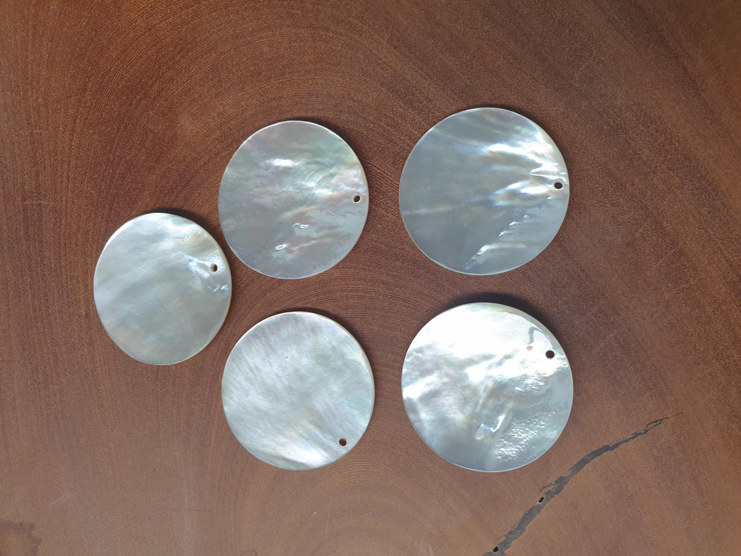 <p>Mother of Pearl polished discs with hole 40mm diameter. Natural curve. Made from A grade Mother of Pearl shell.</p>