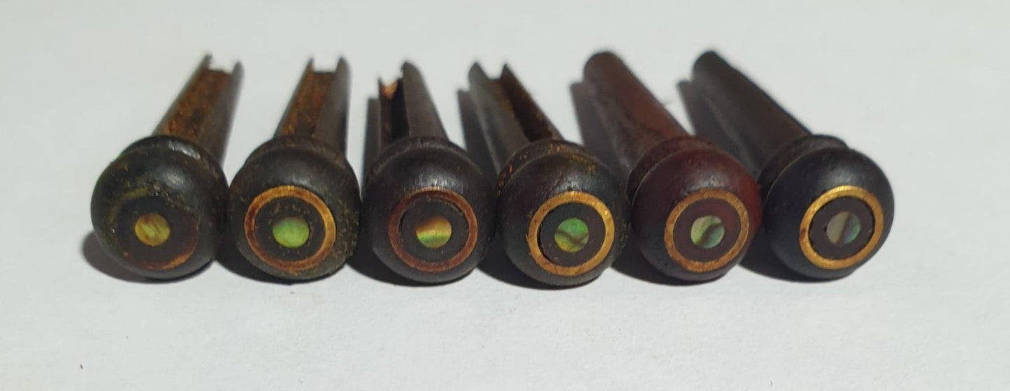 1 set (6pcs) Guitar bridge pins Rosewood with brass and Paua dot. Tapered shaft string slot running the full length of shaft. Diameter at top of shaft 5.35mm (0.21") length of shaft 22.5mm (0.886") . Will fit most guitar models.