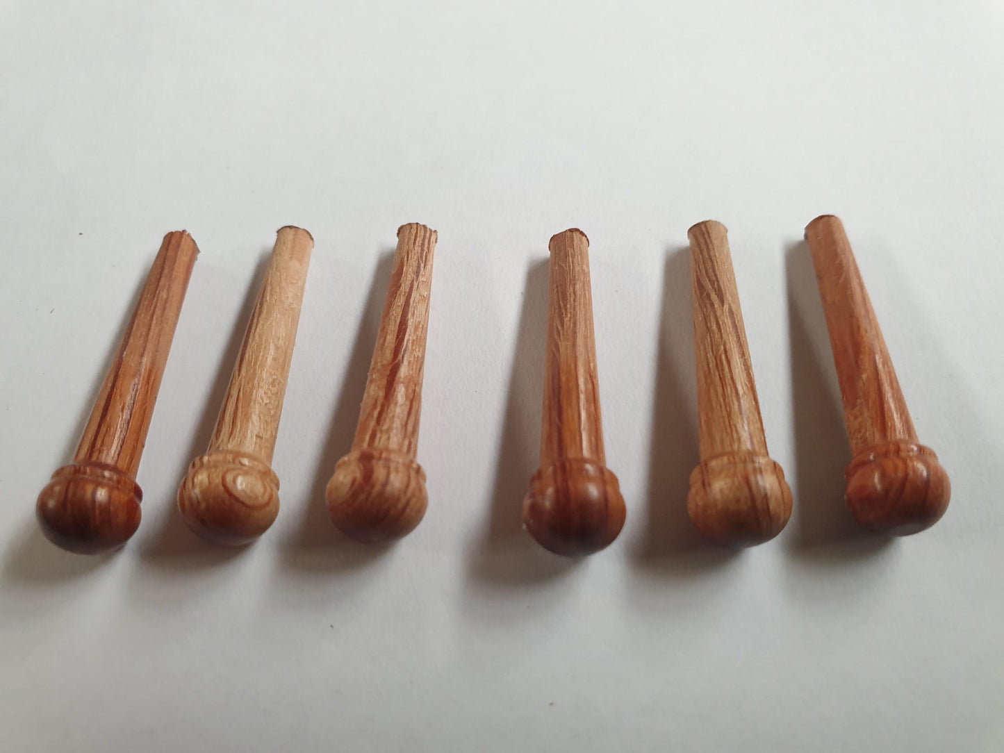 1 set (6pcs) Guitar bridge pins size 2A Sheoak. Tapered shaft string slot running the full length of shaft. Diameter at top of shaft 5.6mm (0.22") length of shaft 25.5mm (1") . Will fit the following models - Martin guitars since 1994,as well as D-28 older Gibson guitars,and others.