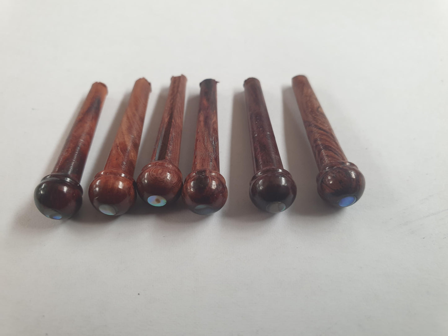 1 set (6pcs) Guitar bridge pins size 2A Rosewood with Paua dot. Tapered shaft string slot running the full length of shaft. Diameter at top of shaft 5.6mm (0.22") length of shaft 25.5mm (1") . Will fit the following models - Martin guitars since 1994,as well as D-28 older Gibson guitars,and others.