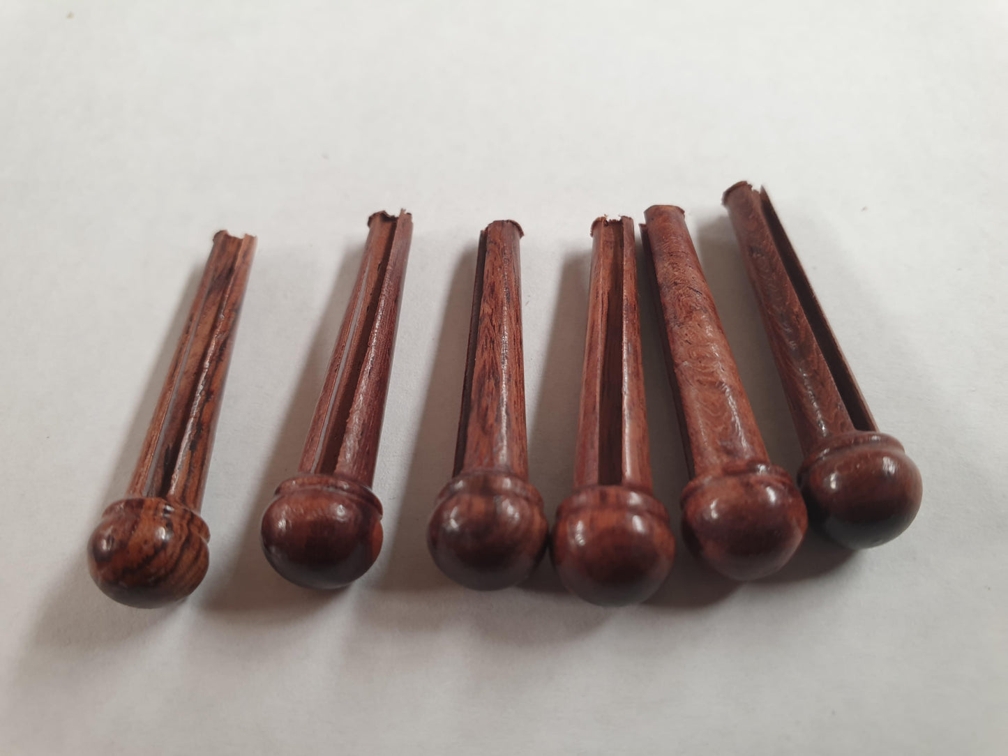 1 set (6pcs) Guitar bridge pins size 2A Rosewood. Tapered shaft string slot running the full length of shaft. Diameter at top of shaft 5.6mm (0.22") length of shaft 25.5mm (1") . Will fit the following models - Martin guitars since 1994,as well as D-28 older Gibson guitars,and others.