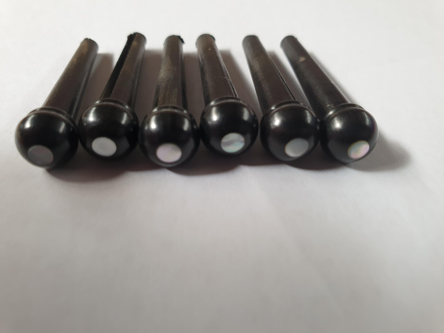 1 set (6pcs) Guitar bridge pins size 2A Ebony with White Mother of Pearl dot Tapered shaft string slot running the full length of shaft. Diameter at top of shaft 5.6mm (0.22") length of shaft 25.5mm (1") . Will fit the following models - Martin guitars since 1994,as well as D-28 older Gibson guitars,and others.