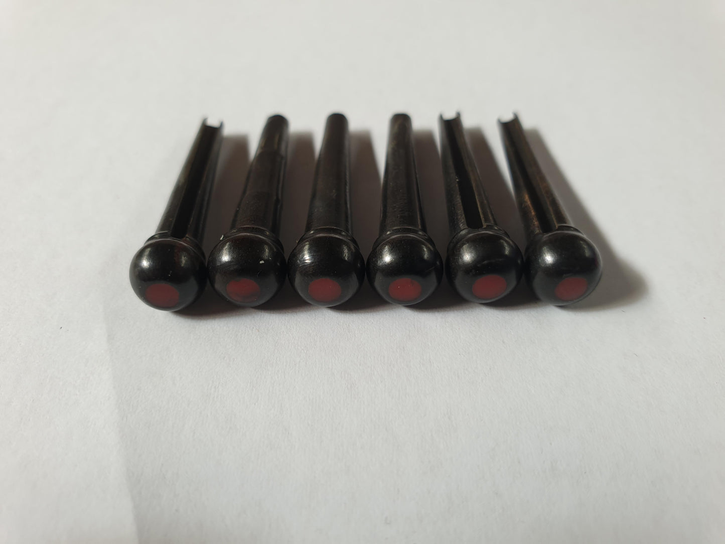 1 set (6pcs) Guitar bridge pins size 2A Ebony with bloody jasper dot. Tapered shaft string slot running the full length of shaft. Diameter at top of shaft 5.6mm (0.22") length of shaft 25.5mm (1") . Will fit the following models - Martin guitars since 1994,as well as D-28 older Gibson guitars,and others.