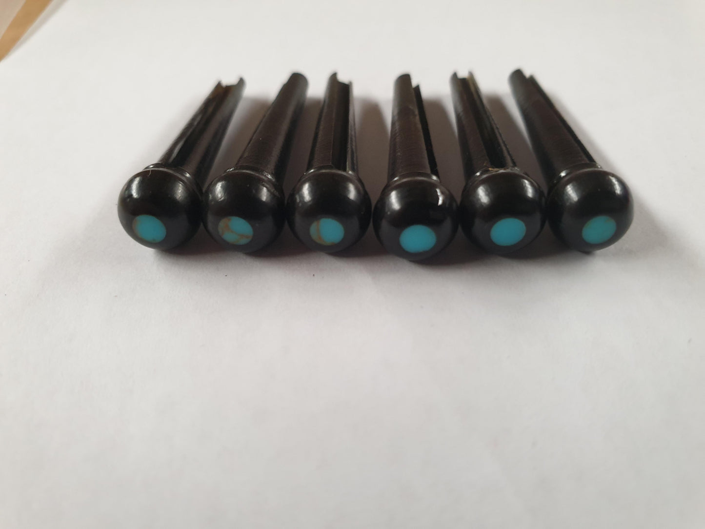 1 set (6pcs) Guitar bridge pins size 2A Ebony with Turquoise dot Tapered shaft string slot running the full length of shaft. Diameter at top of shaft 5.6mm (0.22") length of shaft 25.5mm (1") . Will fit the following models - Martin guitars since 1994,as well as D-28 older Gibson guitars,and others.