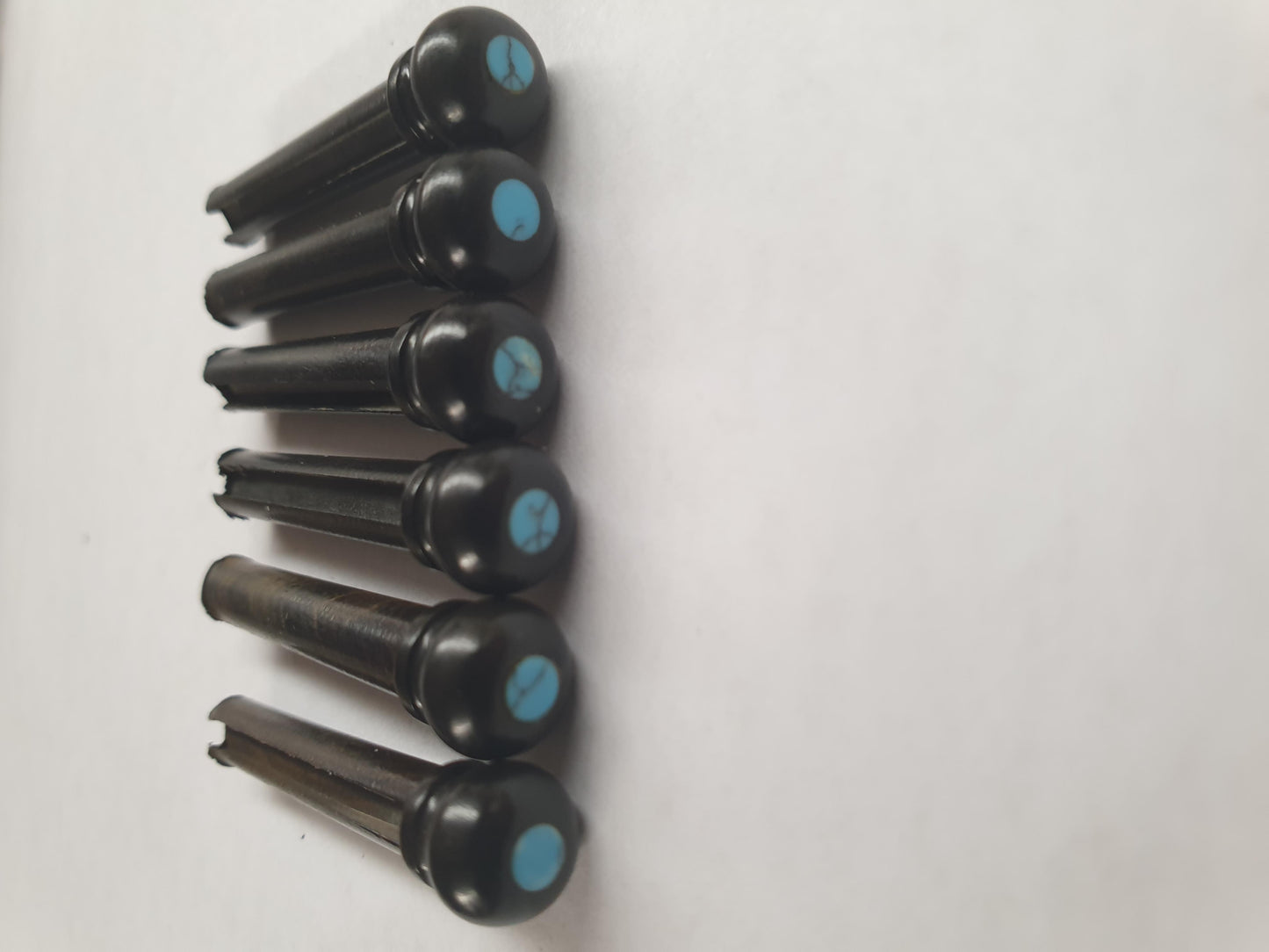1 set (6pcs) Guitar bridge pins size 1 Ebony with Turquoise dot Tapered shaft string slot running the full length of shaft. Diameter at top of shaft 5.3mm (0.21") length of shaft 22.9mm (0.9") . Will fit the following models - Martin guitars prior to 1994 (except HD-28), Collings guitars, prior to 2002, Blanchard, Garrison, Goodall, Ryan, Santa Cruz, Taylor, Larrivee D-03R and others.