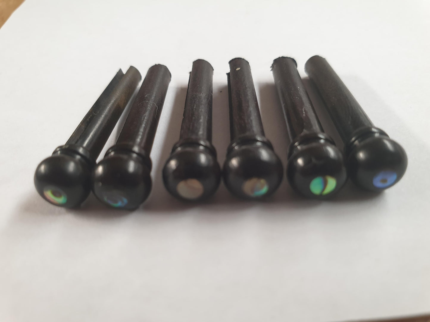1 set (6pcs) Guitar bridge pins size 1 Ebony with Paua dot Tapered shaft string slot running the full length of shaft. Diameter at top of shaft 5.3mm (0.21") length of shaft 22.9mm (0.9") . Will fit the following models - Martin guitars prior to 1994 (except HD-28), Collings guitars, prior to 2002, Blanchard, Garrison, Goodall, Ryan, Santa Cruz, Taylor, Larrivee D-03R and others.