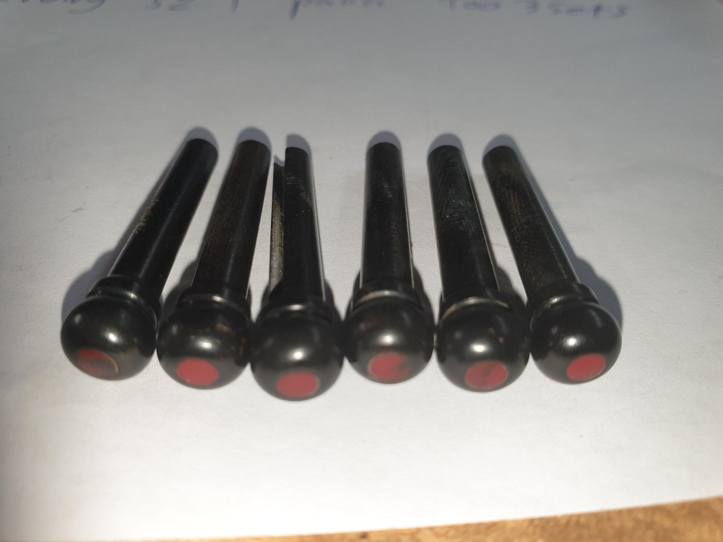 1 set (6pcs) Guitar bridge pins size 1 Ebony with Bloody Jasper dot Tapered shaft string slot running the full length of shaft. Diameter at top of shaft 5.3mm (0.21") length of shaft 22.9mm (0.9") . Will fit the following models - Martin guitars prior to 1994 (except HD-28), Collings guitars, prior to 2002, Blanchard, Garrison, Goodall, Ryan, Santa Cruz, Taylor, Larrivee D-03R and others.
