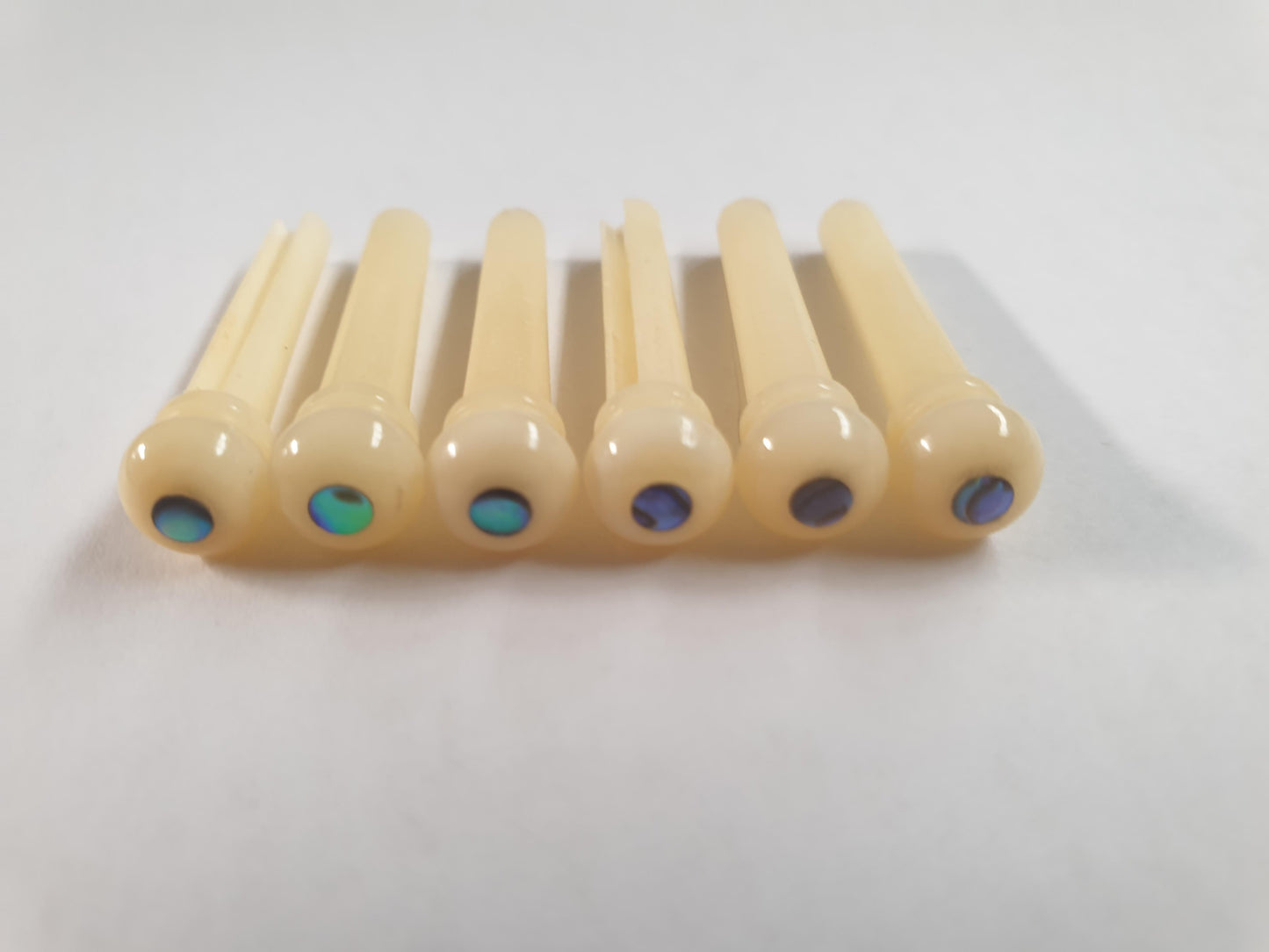 1 set (6pcs) Guitar bridge pins size 1 vintage bone with Paua dot Tapered shaft string slot running the full length of shaft. Diameter at top of shaft 5.3mm (0.21") length of shaft 22.9mm (0.9") . Will fit the following models - Martin guitars prior to 1994 (except HD-28), Collings guitars, prior to 2002, Blanchard, Garrison, Goodall, Ryan, Santa Cruz, Taylor, Larrivee D-03R and others.