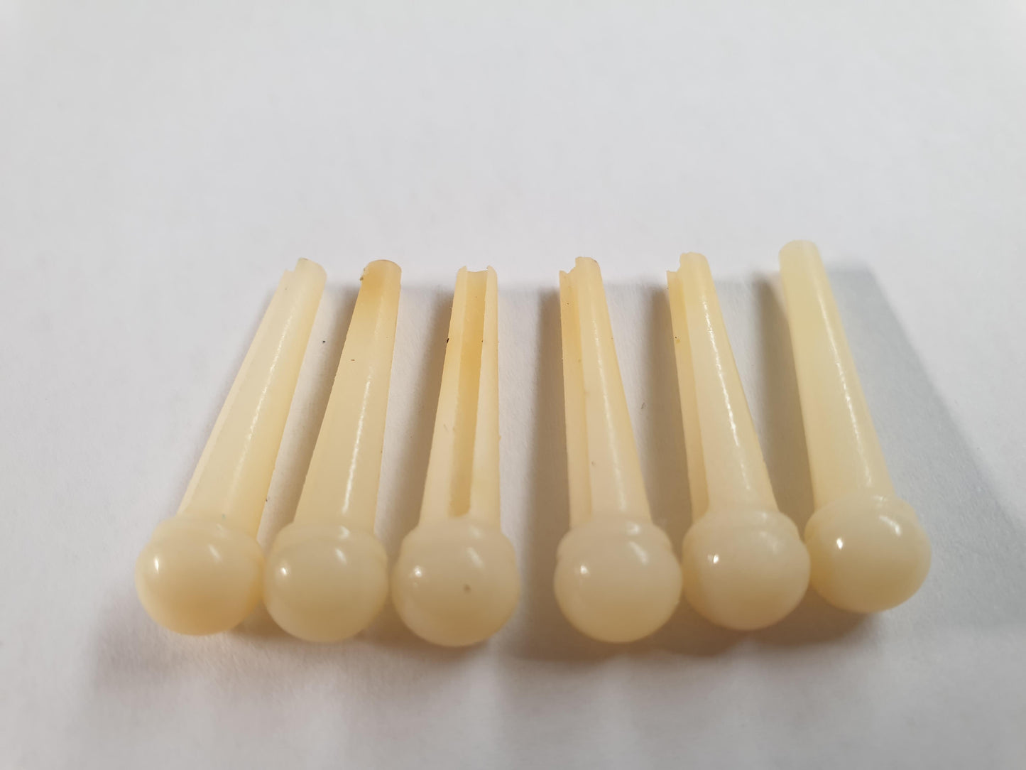 1 set (6pcs) Guitar bridge pins size 2A Vintage bone. Tapered shaft string slot running the full length of shaft. Diameter at top of shaft 5.6mm (0.22") length of shaft 25.5mm (1") . Will fit the following models - Martin guitars since 1994,as well as D-28 older Gibson guitars,and others.