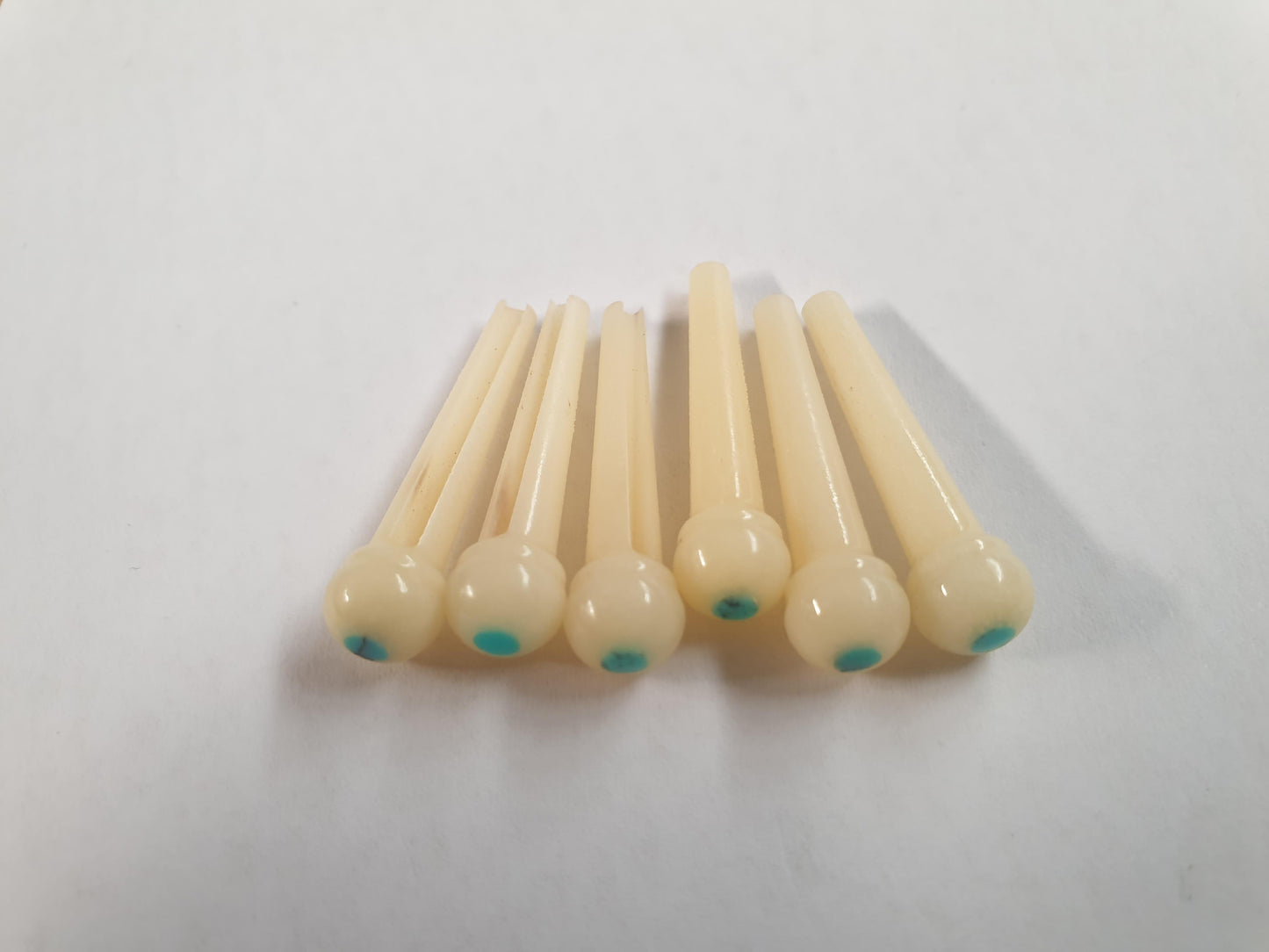 1 set (6pcs) Guitar bridge pins size 2A Vintage bone with Turquoise dot. Tapered shaft string slot running the full length of shaft. Diameter at top of shaft 5.6mm (0.22") length of shaft 25.5mm (1") . Will fit the following models - Martin guitars since 1994,as well as D-28 older Gibson guitars,and others.