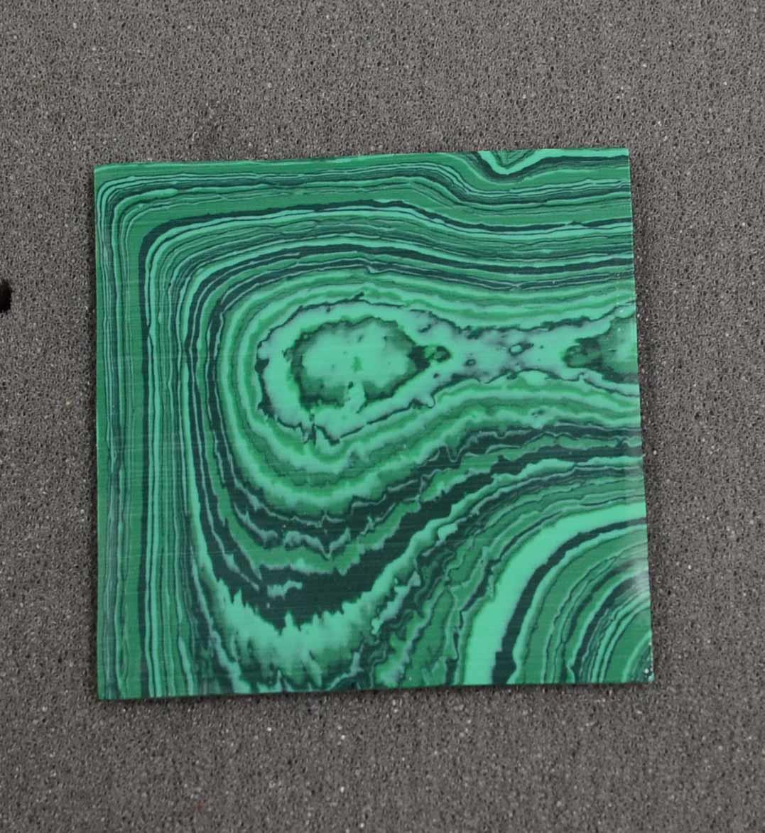 Malachite C025 artificial stone blanks polished 1 side 50x50x2.5mm suitable for inlay. Can be cut with standard cutting tools - jewellery saw similar in characteristics to mother of pearl (hardness approx. 3. Can be sanded and polished same way as shell material. All pcs are A grade good on both sides.