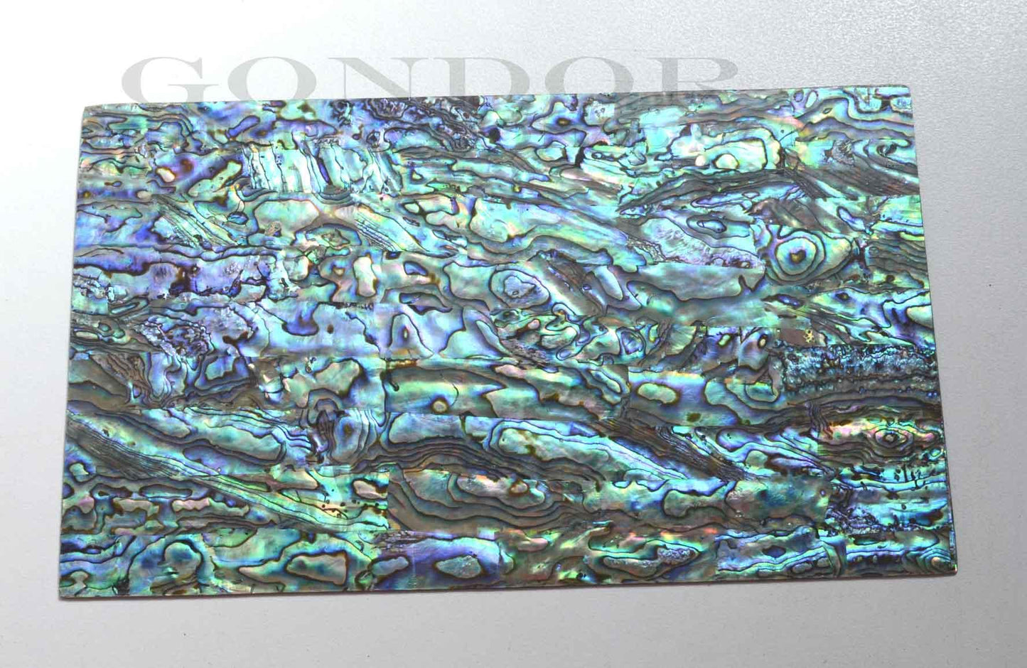 New Zealand Paua shell laminated shell sheets A grade blue, green, pink colour made from genuine shell. Each sheet has shell throughout consisting of layers of smaller shell pcs. Sheet size 235 x 135mm (9.25 x 5.3"). Thickness 0.5mm (0.02") Ideal for inlay work, jewellery, knife handles. Economical and easy to cut. All layers are A grade same consistency throughout the sheet.