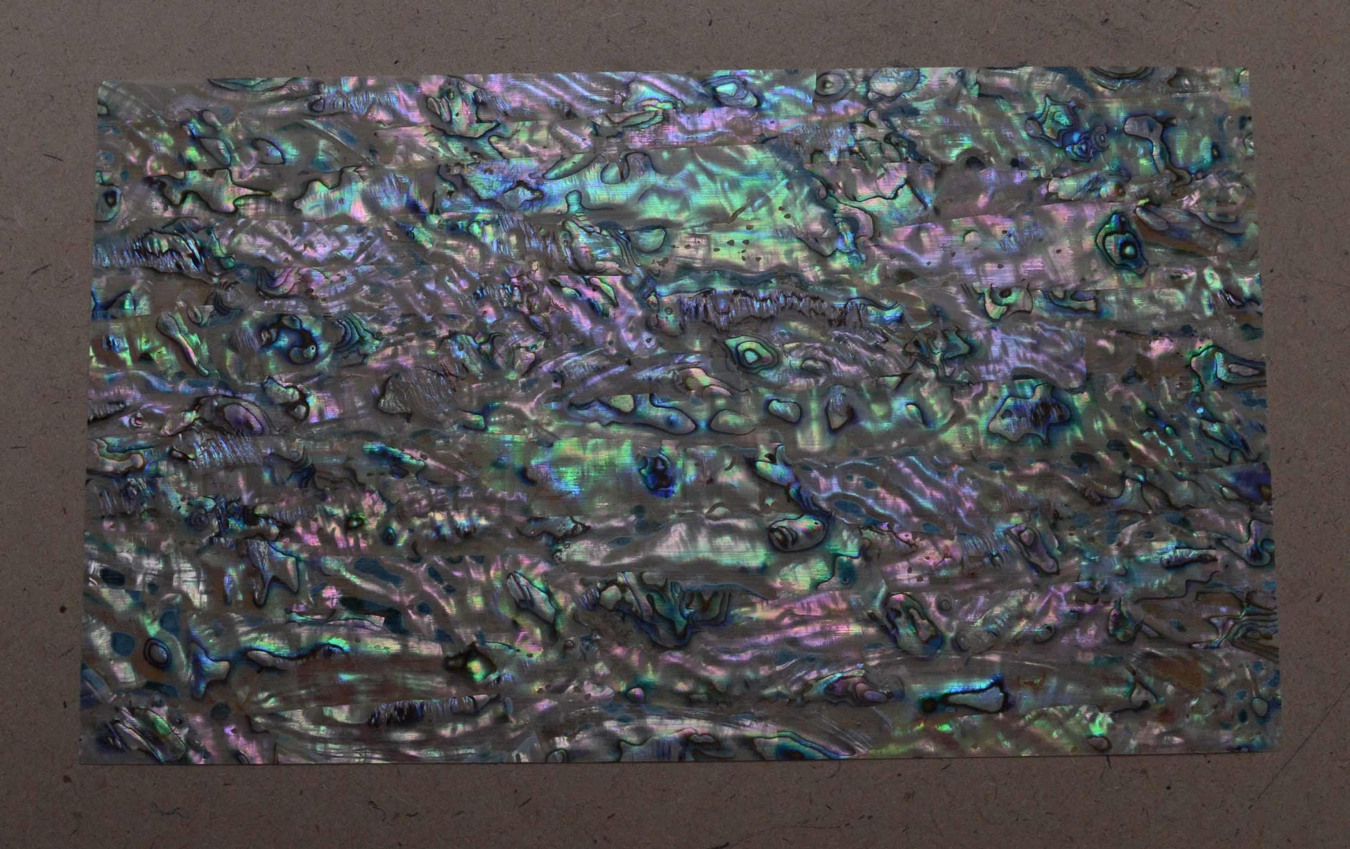 <p>New Zealand Paua shell laminated shell sheets C grade mixed blue, green, pink colour made from genuine shell. Each sheet has shell throughout consisting of layers of smaller shell pcs. Sheet size 235 x 135mm (9.25 x 5.3"). Thickness 0.5mm (0.02") Ideal for inlay work, jewellery, knife handles. Economical and easy to cut. All layers are same consistency throughout the sheet. C grade sheets include some worm hole and shell skin.</p>