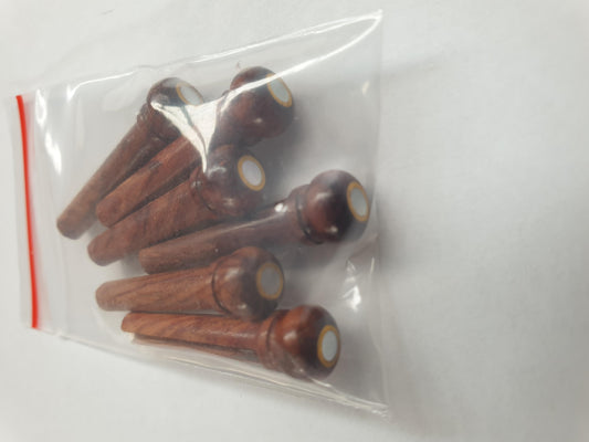 1 set (6pcs) Guitar bridge pins Rosewood with brass ring and White MOP dot size 1 Tapered shaft string slot running the full length of shaft. Diameter at top of shaft 5.3mm (0.21") length of shaft 22.9mm (0.9") . Will fit the following models - Martin guitars prior to 1994 (except HD-28), Collings guitars, prior to 2002, Blanchard, Garrison, Goodall, Ryan, Santa Cruz, Taylor, Larrivee D-03R and others.