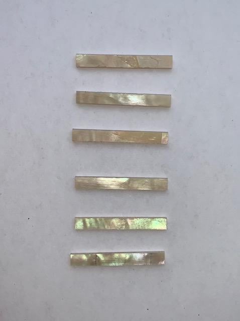 Australian Greenlip abalone solid shell straight strips 1.5mm (0.059") width x 25mm (1") length x 1.3mm (0.05") thickness. A grade quality good on both sides, flat and uniform in thickness and width. Ideal for use in purfling on musical instruments - Ukuleles, guitars, mandolins etc. as well as in furniture, jewellery ans other decorative applications.