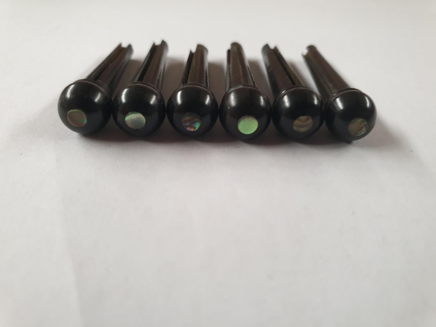 1 set (6pcs) Guitar bridge pins  size 2A Ebony with Paua dot. Tapered shaft string slot running the full length of shaft. Diameter at top of shaft 5.6mm (0.22") length of shaft 25.5mm (1") . Will fit the following models - Martin guitars since 1994,as well as D-28 older Gibson guitars,and others.