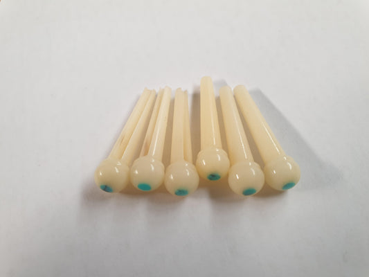 1 set (6pcs) Guitar bridge pins  size 2A Vintage bone with Turquoise dot. Tapered shaft string slot running the full length of shaft. Diameter at top of shaft 5.6mm (0.22") length of shaft 25.5mm (1") . Will fit the following models - Martin guitars since 1994,as well as D-28 older Gibson guitars,and others.