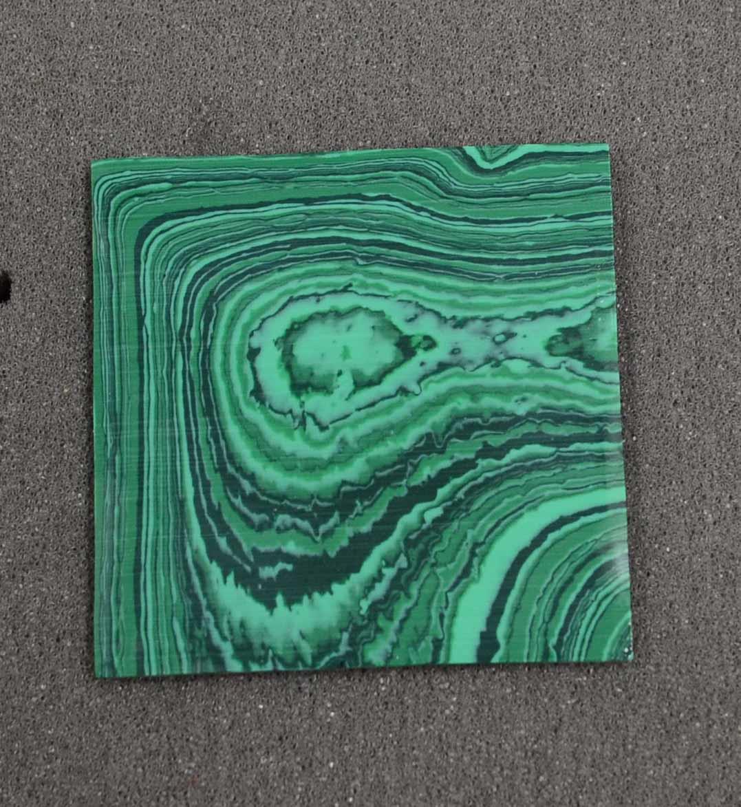 <p>Malachite C025 artificial stone blanks polished 1 side 50x50x2mm suitable for inlay. Can be cut with standard cutting tools - jewellery saw similar in characteristics to mother of pearl (hardness approx. 3. Can be sanded and polished same way as shell material. All pcs are A grade good on both sides.</p>