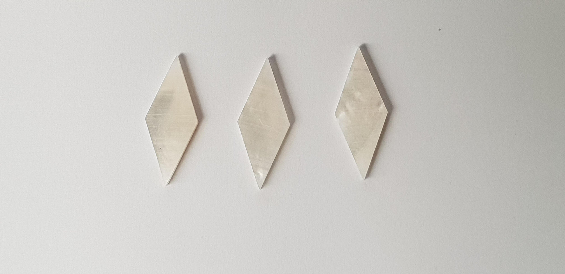 White Mother of Pearl diamonds size 10.5mm  wide x 27mm length x 1.5mm (0.06") thickness. Some uses include fretboard markers, musical instrument inlay, furniture inlay and other general decorative inlay and jewellery applications. All pcs are A grade.