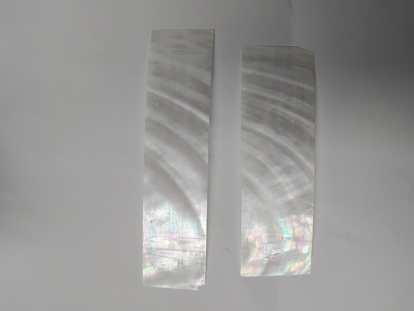 Fresh water pearl feathers white colour&nbsp;feathers 30mm width x 80mm to 120mm length x 0.15mm (0.006") thickness - thinly sliced solid shell pcs. Cut along the curved part of shell they can yield larger pcs then standard solid shell blanks. Ideal for shallow inlay, overlay, fishing lure manufacture and other decorative purposes. Select quality A grade.